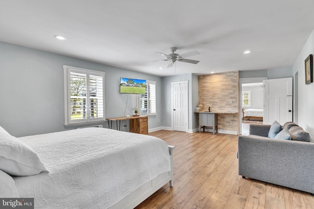 bedroom with light hardwood / wood-style floors, wooden walls, ceiling fan, and a closet