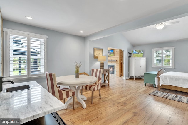 dining area with vaulted ceiling, light hardwood / wood-style floors, ceiling fan, and sink