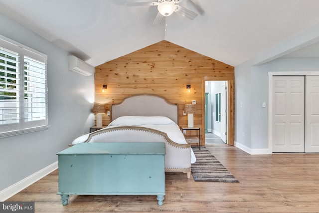 bedroom featuring an AC wall unit, wood walls, ceiling fan, and hardwood / wood-style floors