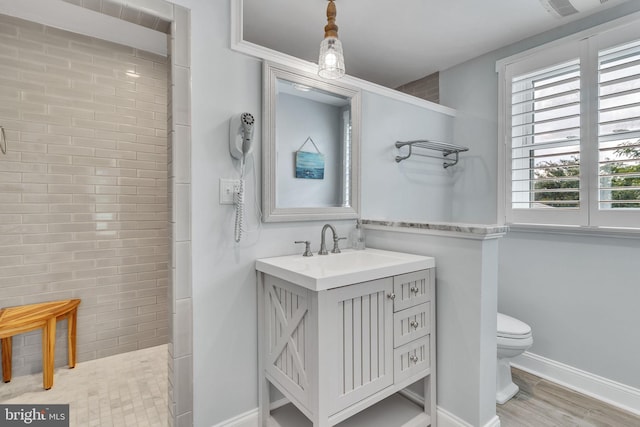 bathroom featuring walk in shower, vanity, hardwood / wood-style floors, and toilet