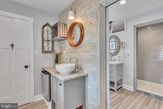 bathroom with walk in shower, vanity, and hardwood / wood-style floors