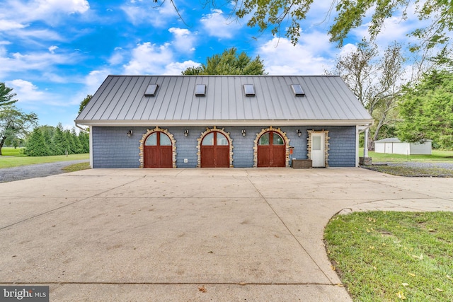 garage featuring a yard and covered porch