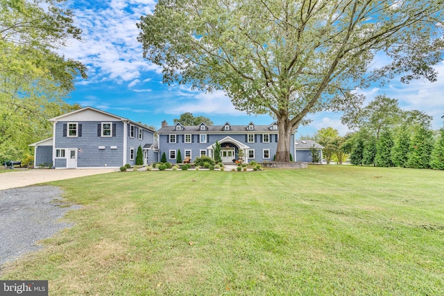 view of front of home with covered porch, a front yard, and a garage