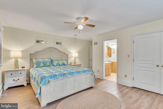 bedroom featuring ceiling fan, light hardwood / wood-style flooring, and ensuite bath