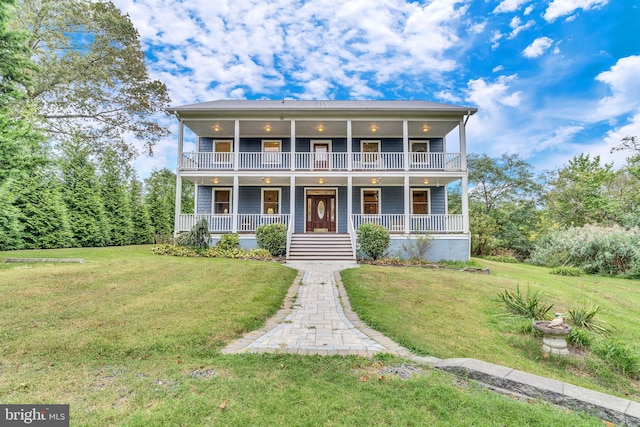 view of front facade with a balcony, a porch, and a front lawn