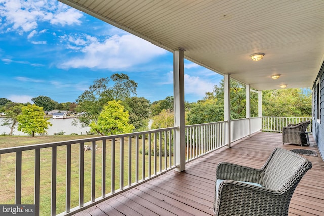 deck with a yard and a water view