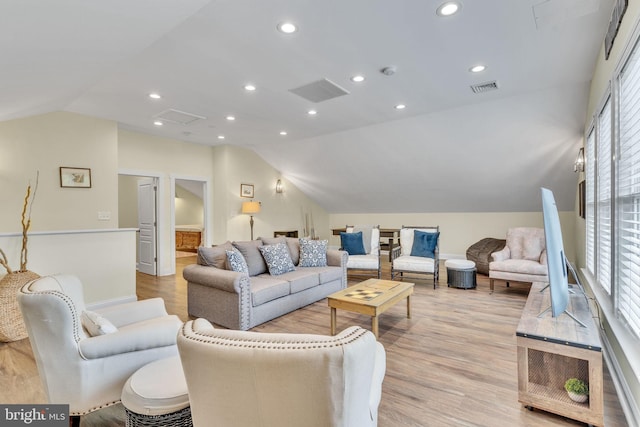 living room featuring light wood-type flooring and vaulted ceiling