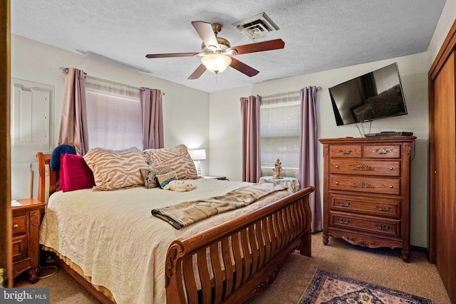 carpeted bedroom with ceiling fan and a textured ceiling