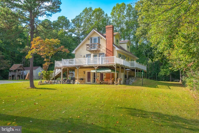 back of house featuring a wooden deck and a yard