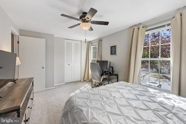 bedroom featuring multiple windows, ceiling fan, and light colored carpet