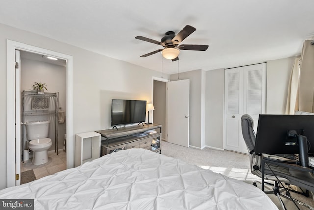 carpeted bedroom with a closet, connected bathroom, and ceiling fan