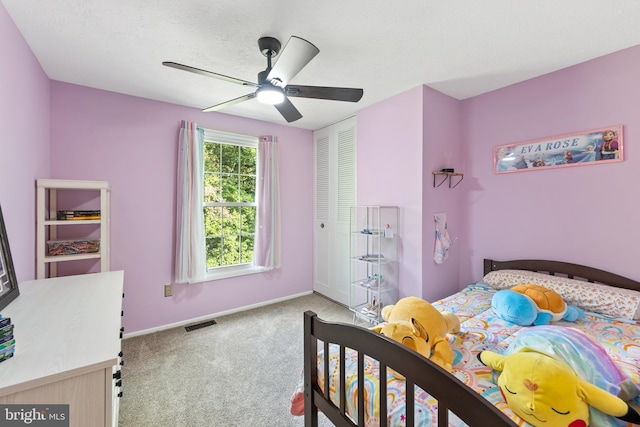 carpeted bedroom featuring a textured ceiling, ceiling fan, and a closet