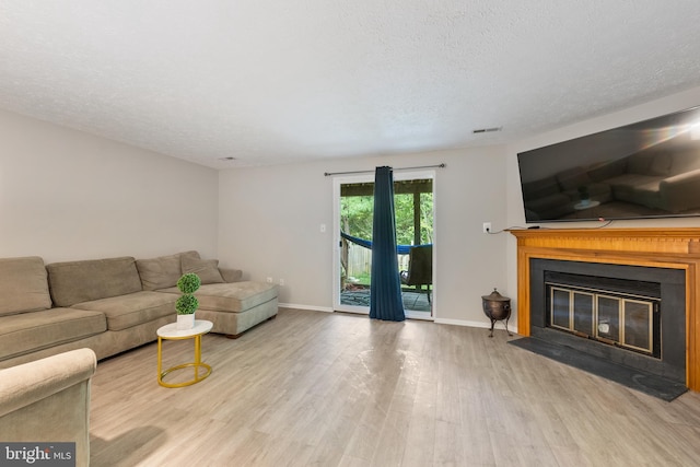 living room with a textured ceiling and light hardwood / wood-style floors