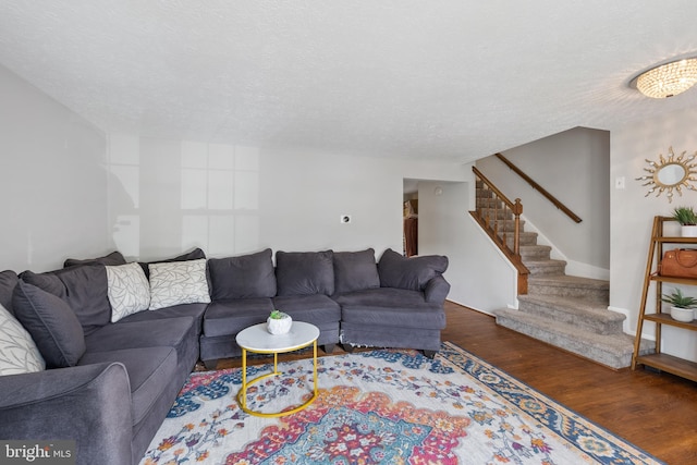 living room featuring a textured ceiling and dark wood-type flooring