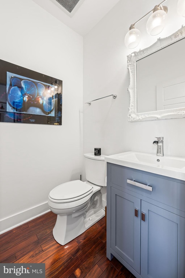 bathroom featuring vanity, toilet, and hardwood / wood-style flooring