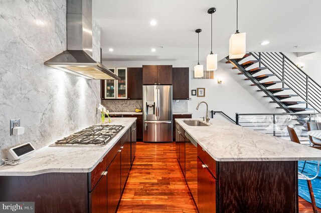 kitchen featuring dark hardwood / wood-style flooring, stainless steel appliances, sink, and wall chimney range hood