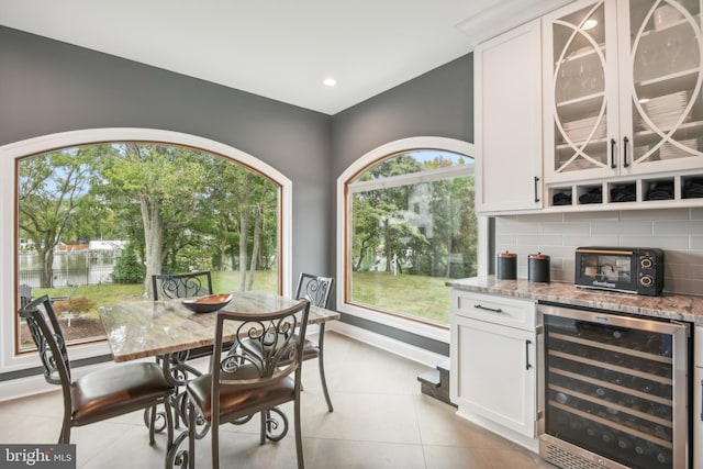 tiled dining room featuring bar area and beverage cooler