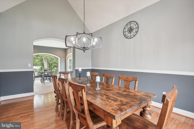 dining room featuring light hardwood / wood-style flooring, a notable chandelier, and high vaulted ceiling