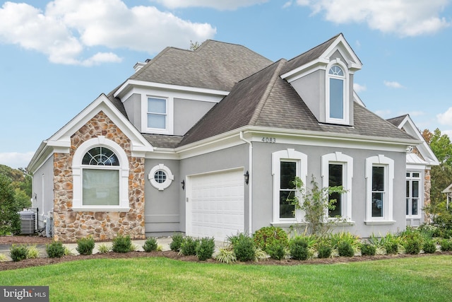 view of front of property with a front lawn, central AC unit, and a garage