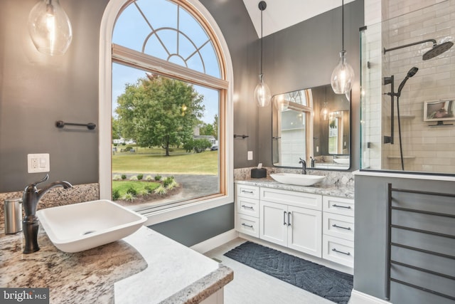 bathroom with vanity, vaulted ceiling, and tiled shower