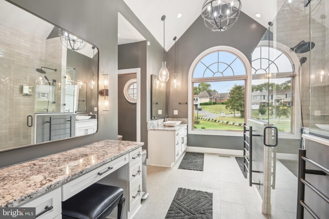 bathroom featuring walk in shower, lofted ceiling, vanity, and an inviting chandelier