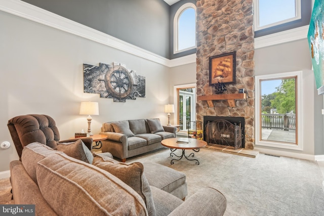 living room featuring carpet flooring, a towering ceiling, ornamental molding, and a fireplace