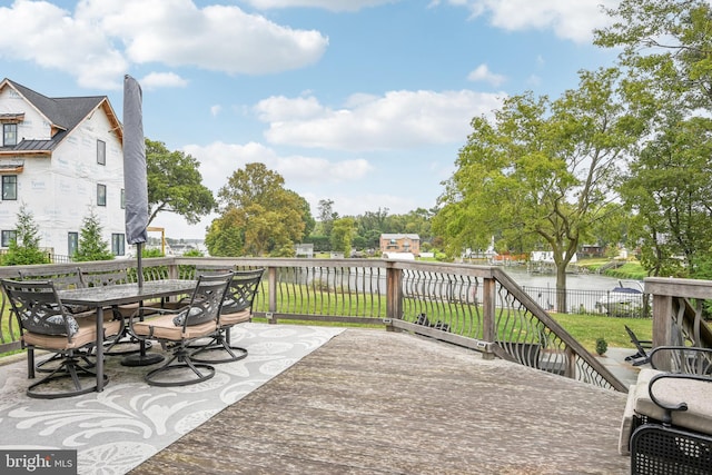 deck featuring a water view, a lawn, and a patio area