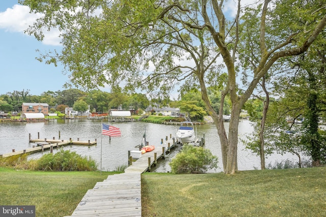 view of dock featuring a lawn and a water view