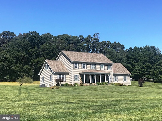 colonial house featuring central AC and a front lawn