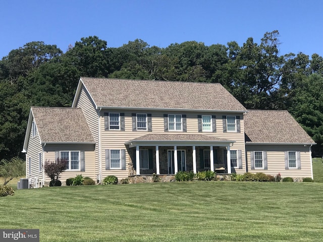 colonial house with a front yard and central AC