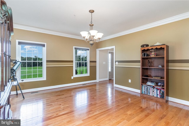 interior space featuring ornamental molding, hardwood / wood-style floors, and a chandelier