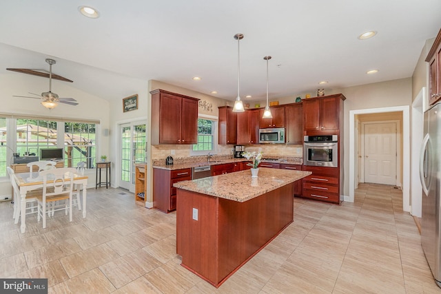 kitchen featuring lofted ceiling, a kitchen island, stainless steel appliances, pendant lighting, and light stone counters