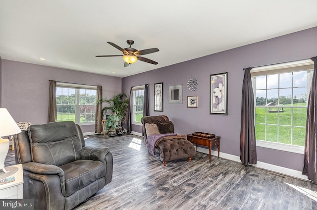 living room featuring dark wood-type flooring and ceiling fan