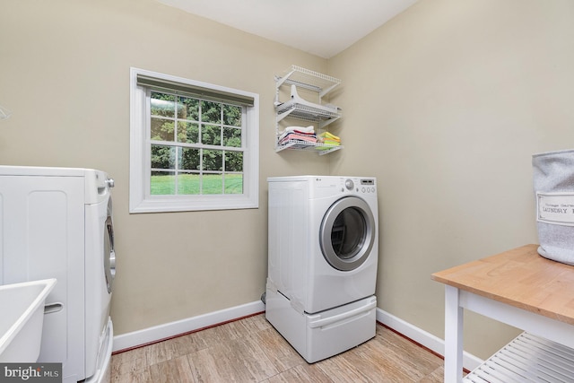 laundry room featuring separate washer and dryer and light wood-type flooring