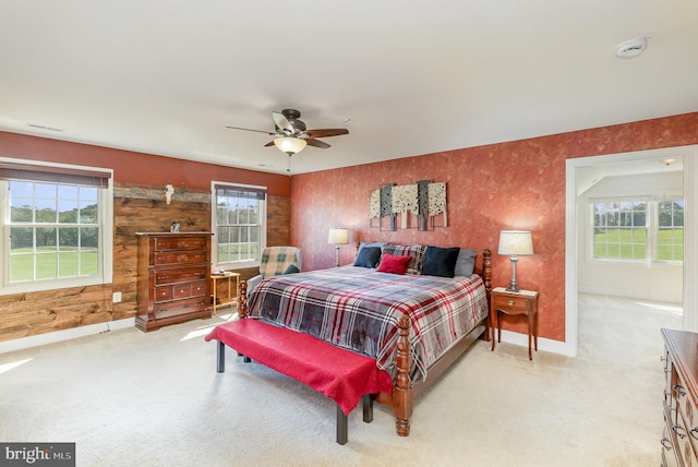 bedroom featuring ceiling fan, light carpet, and multiple windows