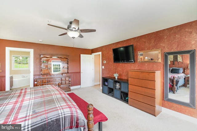 carpeted bedroom with ensuite bathroom and ceiling fan