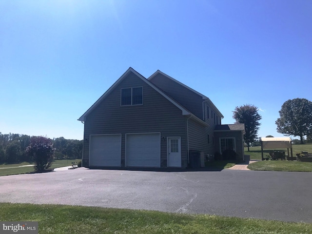 view of side of property with a yard and a garage