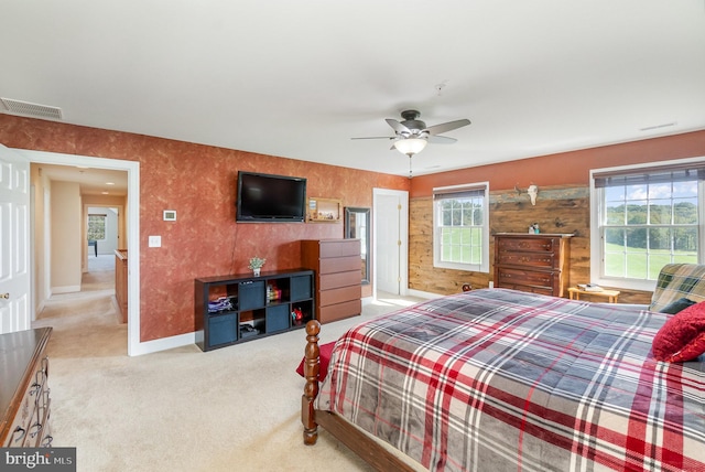 bedroom with ceiling fan, light carpet, and multiple windows