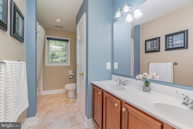 bathroom featuring toilet, a chandelier, and vanity