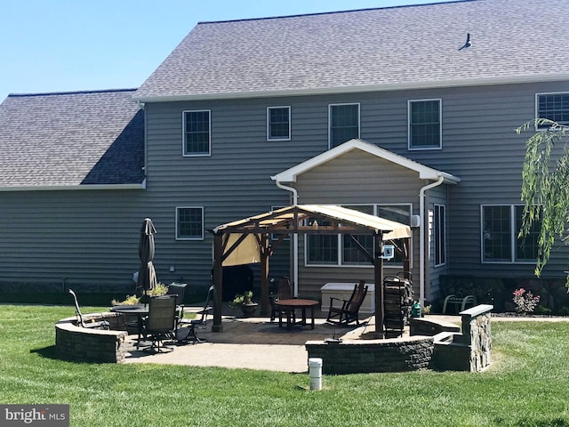 back of house featuring a yard, a patio area, and a fire pit