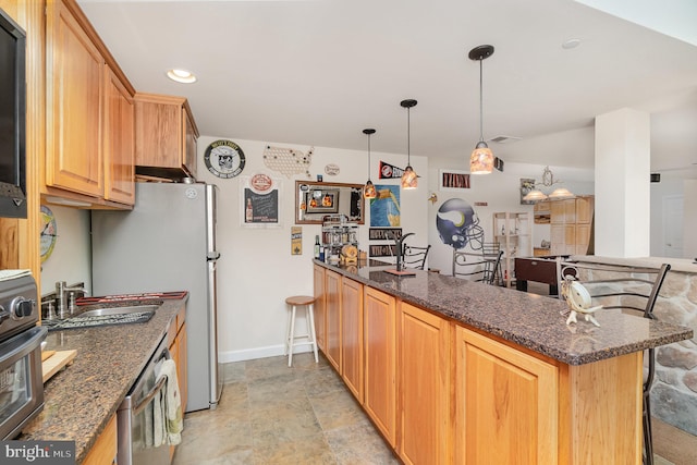 kitchen featuring oven, dark stone countertops, decorative light fixtures, and sink