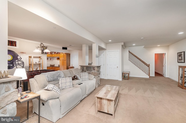 living room with light carpet and an inviting chandelier