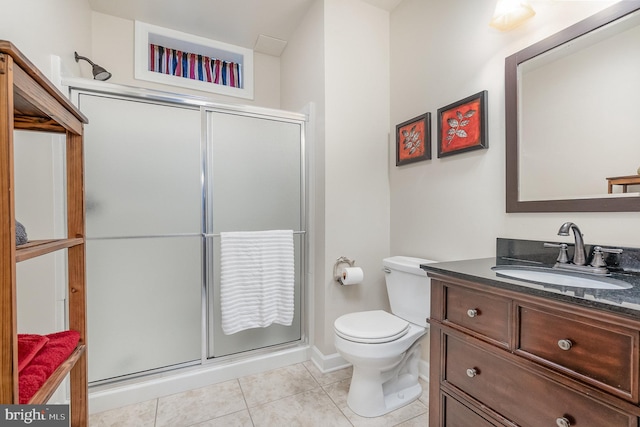 bathroom with a shower with door, vanity, toilet, and tile patterned flooring