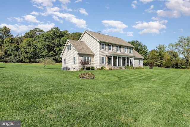 view of front of house with central air condition unit and a front lawn