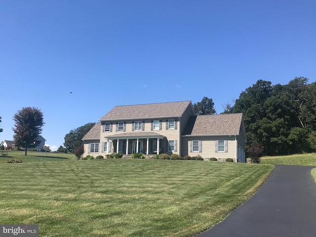 colonial house featuring a front lawn