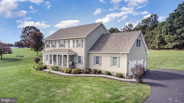 colonial house with a front yard and a garage