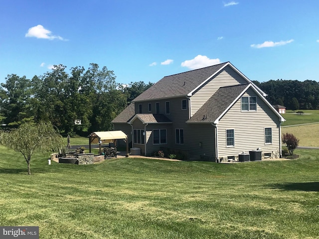 rear view of house featuring a patio area, a gazebo, cooling unit, and a lawn