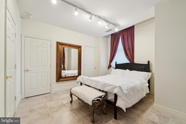 tiled bedroom featuring track lighting