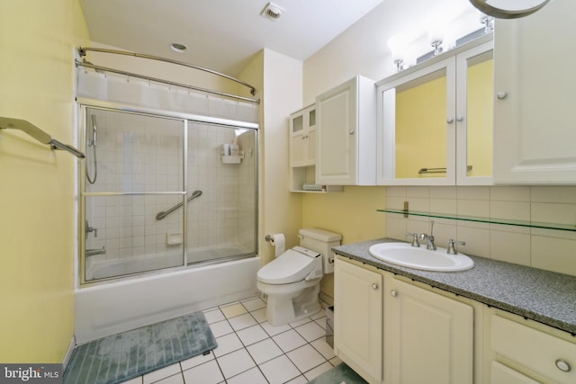 full bathroom featuring tile patterned floors, toilet, combined bath / shower with glass door, decorative backsplash, and vanity