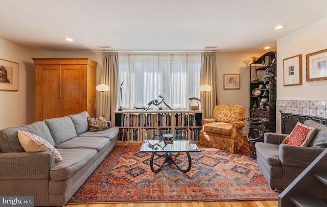 living room with hardwood / wood-style floors and a tile fireplace